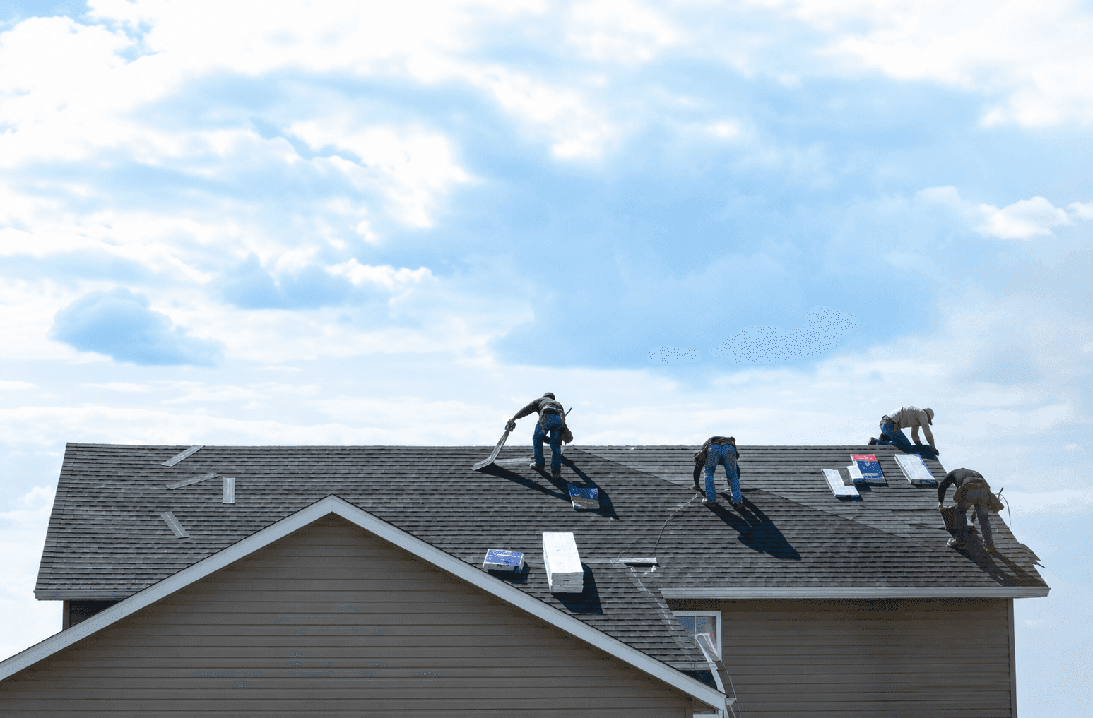 Roofing crew installing shingles on a residential home
