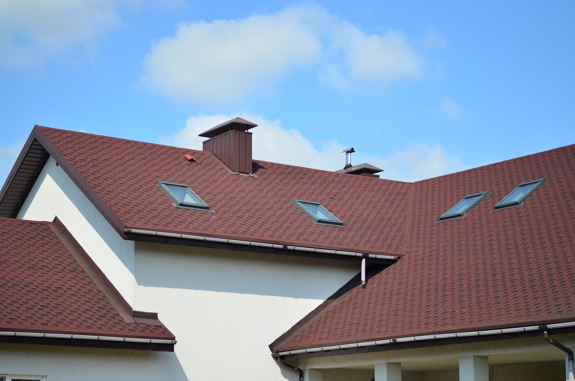 Designer shingle roof with skylights and metal-clad chimney